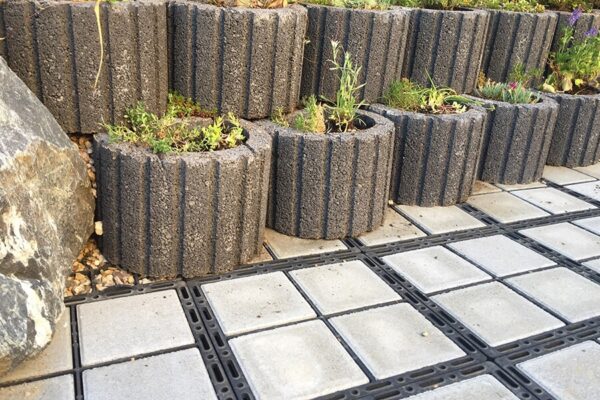 Nahaufnahme von ECORASTER Bloxx Flächen mit Beton Pflanzkübeln