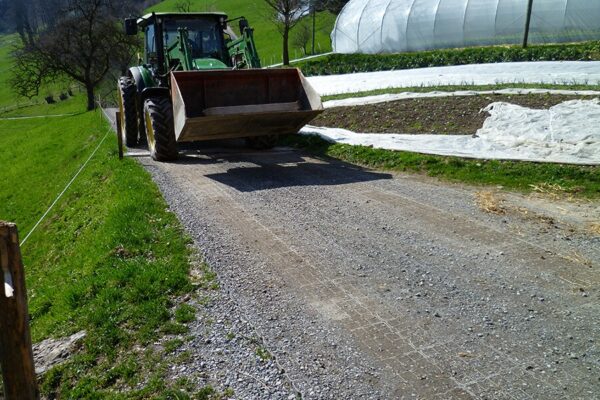 Ein Traktor fährt auf einer mit ECORASTER befestigten Zufahrt