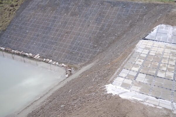 Regenrückhaltebecken mit frisch verlegten ECORASTER Modulen mit Erdnägeln und ECORASTER Bloxx