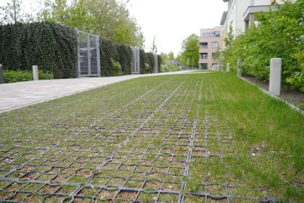 Nahansicht einer Feuerwehrfläche, die mit ECORASTER Green befestigt wurde. Wohngebäude im Hintergrund