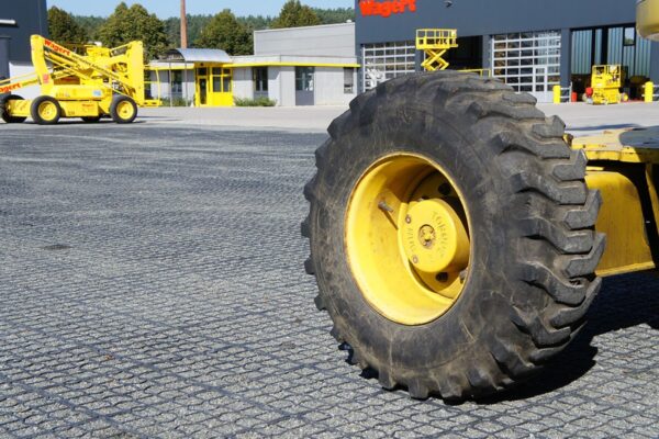 Logisitkfläche mit ECORASTER Mineral und großen Schwerlastmaschinen, im Hintergrund Industriegebäude und Werkstatt