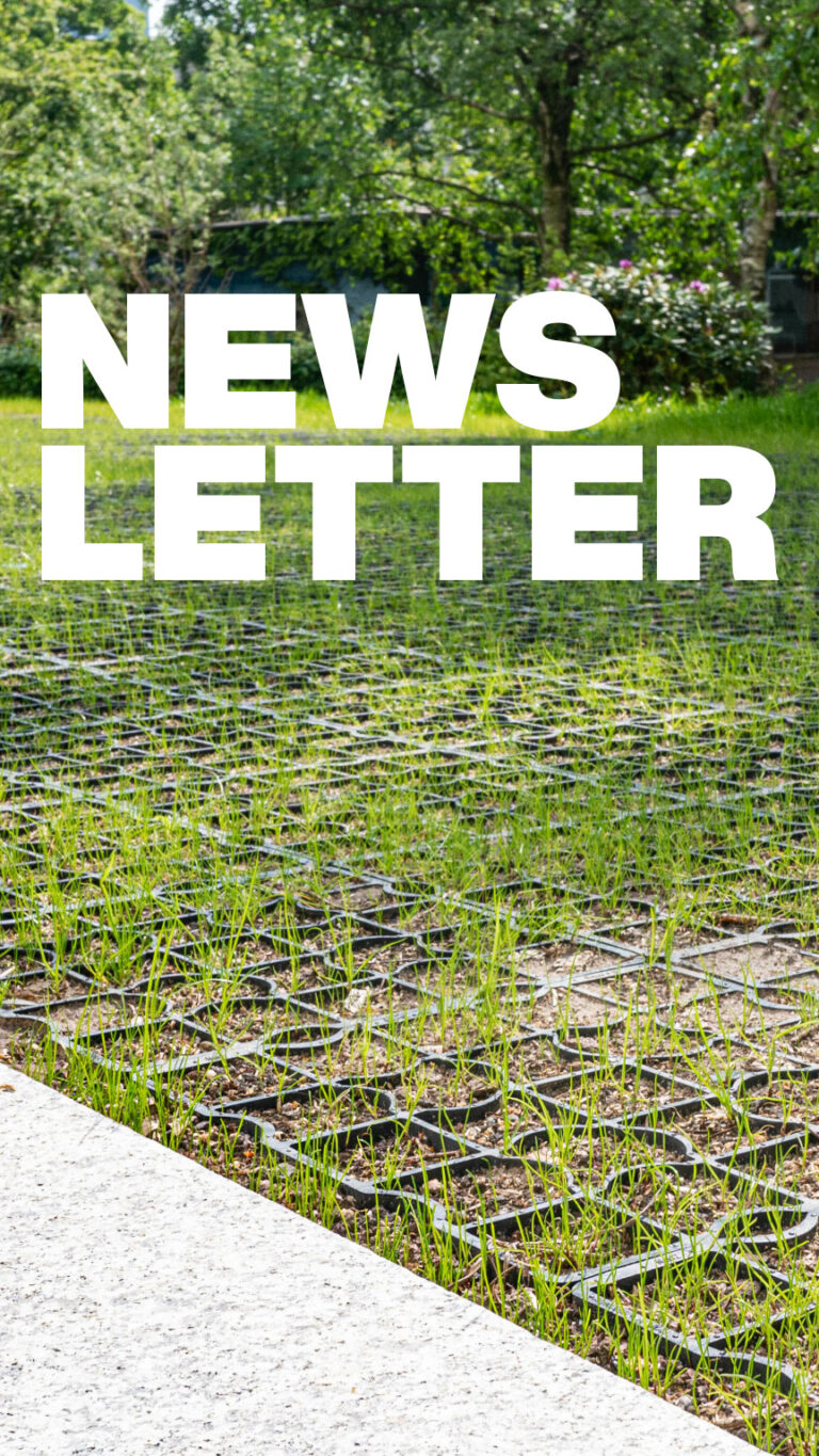 Nahaufnahme von Bodengittern, aus denen Gras herauswächst.