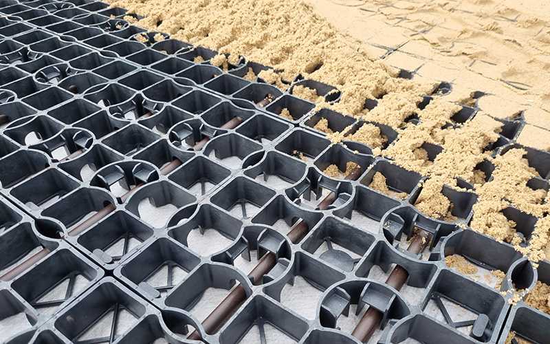 Ecoraster E40 Aqua mit Wasserrohren werden mit Sand befüllt